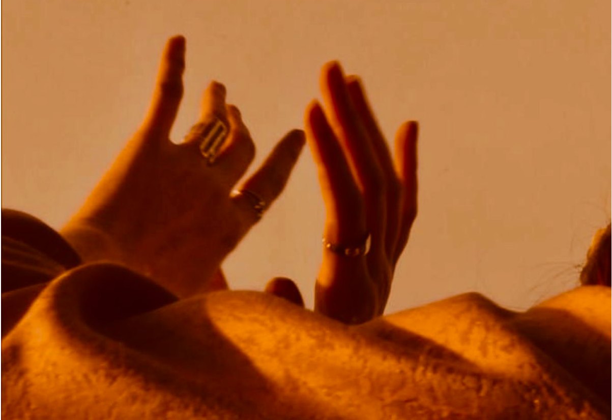 Hands raised against warm evening light.